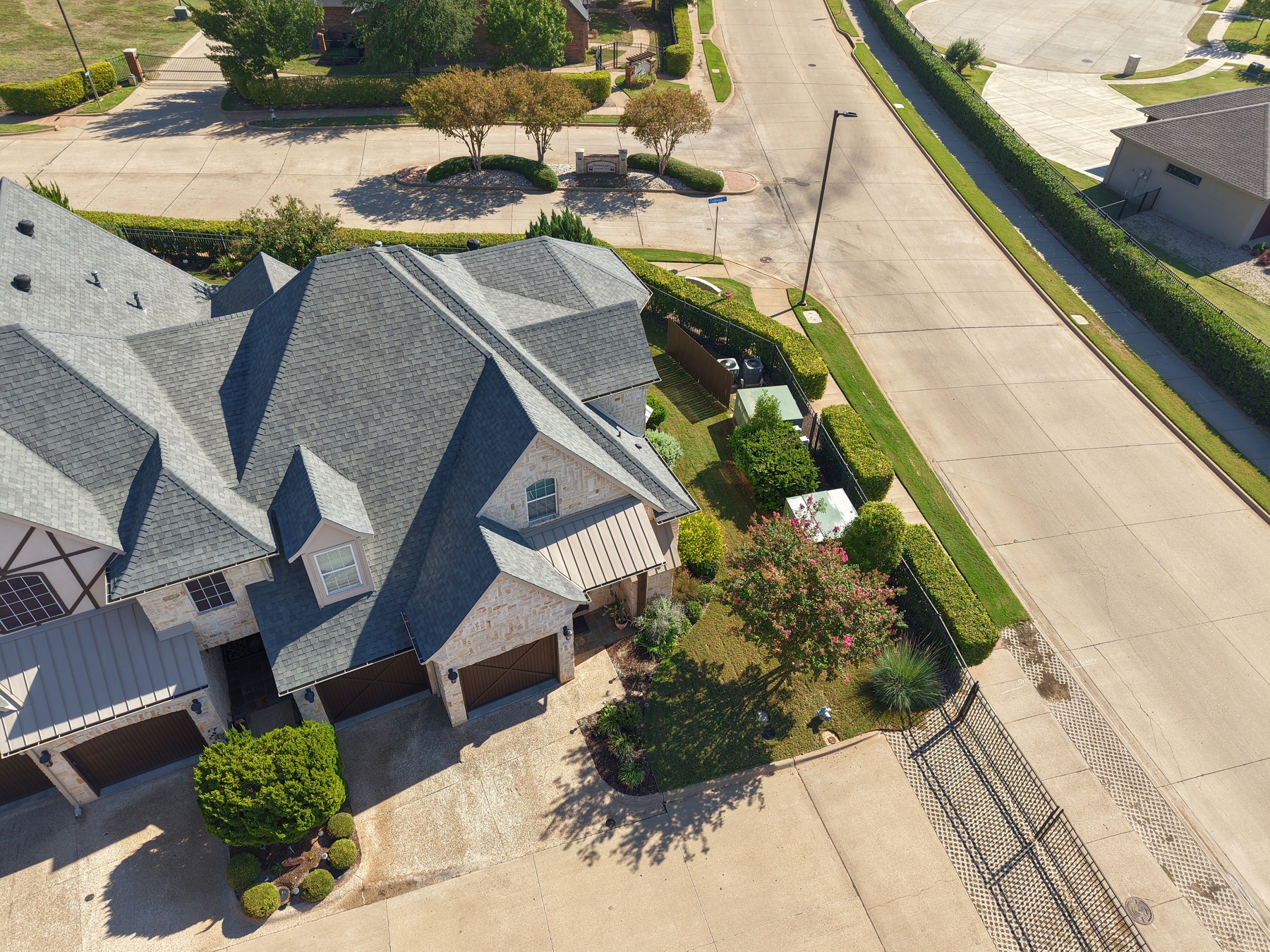 Actual aerial view of a home, its lot, street, and surrounding neighborhood