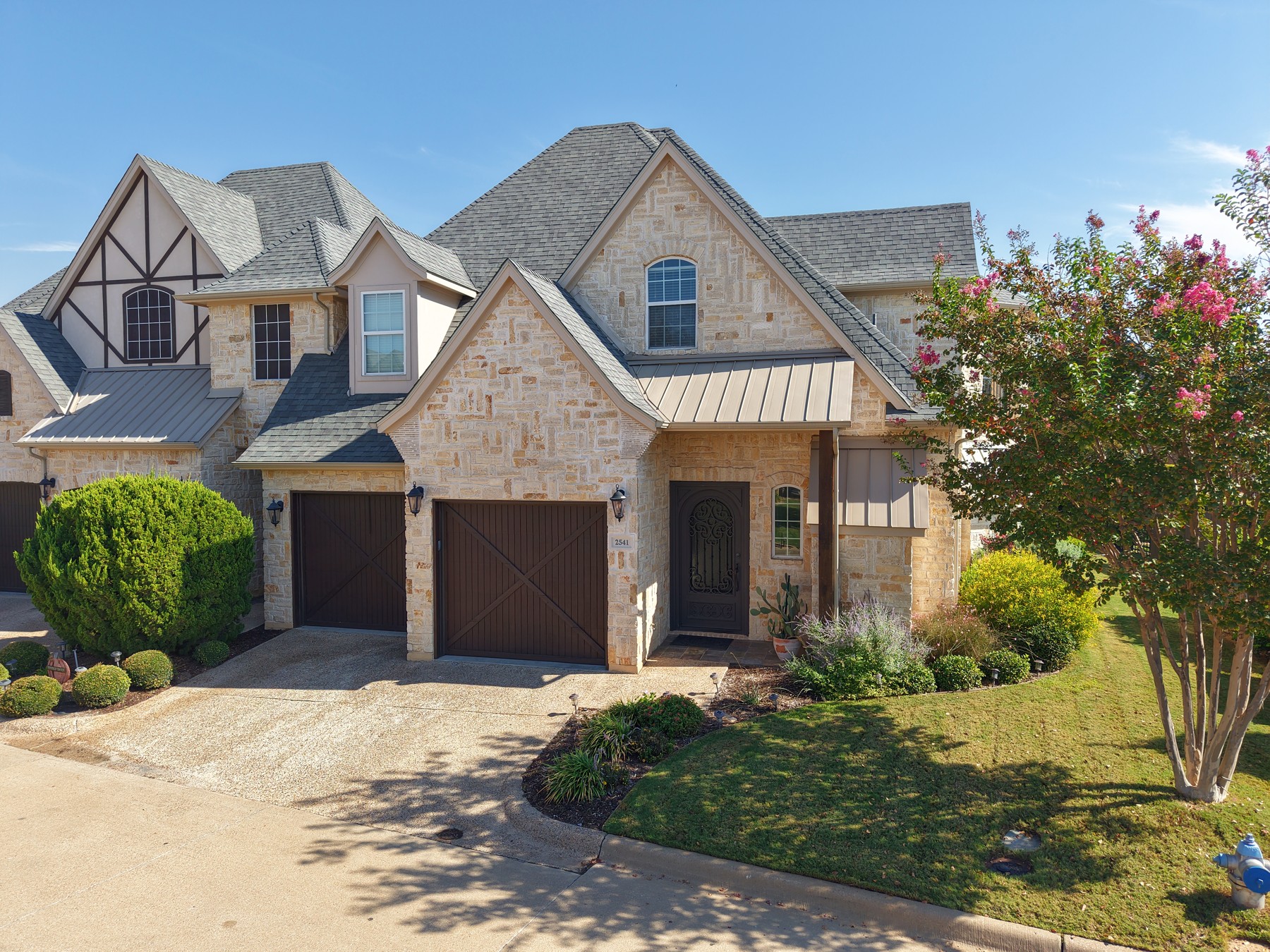 Actual property photography showing a stone home and landscaped front yard